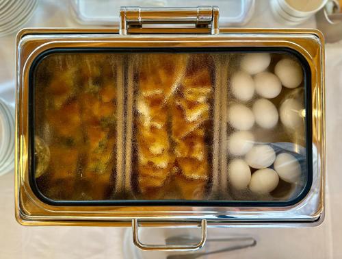 a tray of food in an oven with eggs at Aragosta Hotel in Durrës
