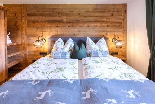 a bedroom with a bed with blue comforter and pillows at Appartement Auszeit in Alpbach