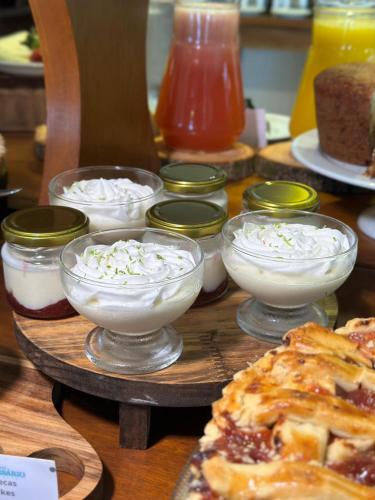 a table with bowls of food and a pizza at Pousada Corsario Buzios in Búzios