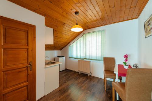 a kitchen and dining room with a wooden ceiling at Perla Lacului in Rişca