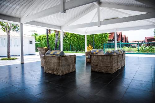 an outdoor patio with wicker chairs and an umbrella at Cotovia 1 in Belas