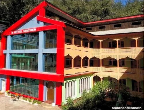 a large building with a red at Siachen Hotel in Kargil