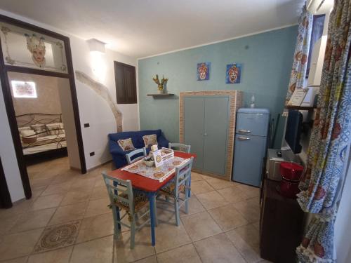 a living room with a table and a kitchen at Cuore e Mare Ortigia in Syracuse