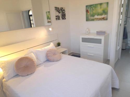 a white bedroom with a white bed with two pillows at Casa Christian Costa Calma beach in Costa Calma
