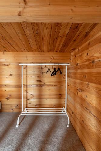 a room with a wooden wall with a bed in it at Walliswood Lodge - Wood Burner, Air Con & Wi-fi, Rural Retreat in Ewhurst