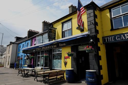 a yellow building with a bench in front of it at The Dundrum Inn B&B in Dundrum