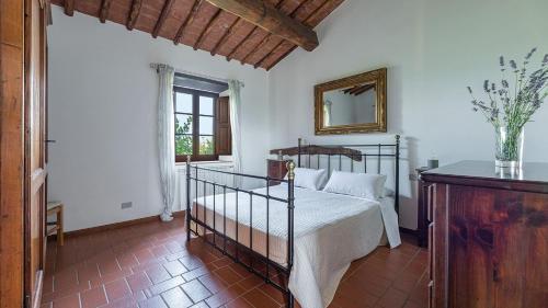 Un dormitorio con una cama y un espejo en la pared. en Lavanda, en Gaiole in Chianti