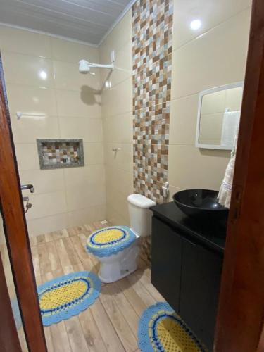 a bathroom with a toilet and a black sink at Casinha Azul in Prado