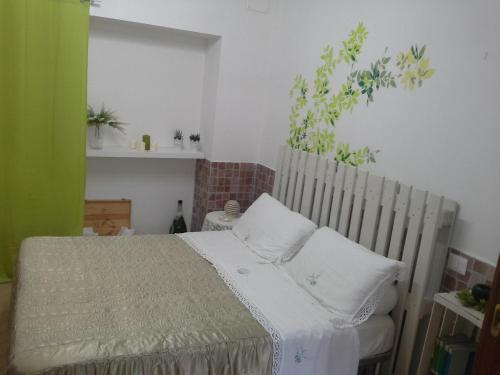 1 dormitorio con 1 cama con 2 almohadas blancas en Giardini Di Capodimonte Apartment en Nápoles