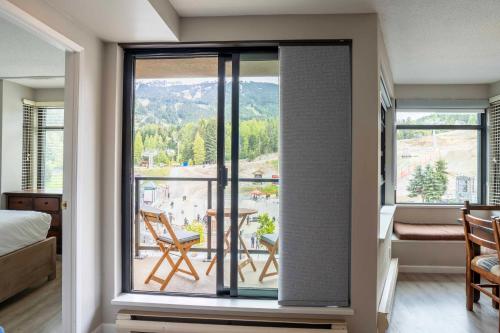a room with a large window with a view at Gibbons Life Accommodations in Whistler
