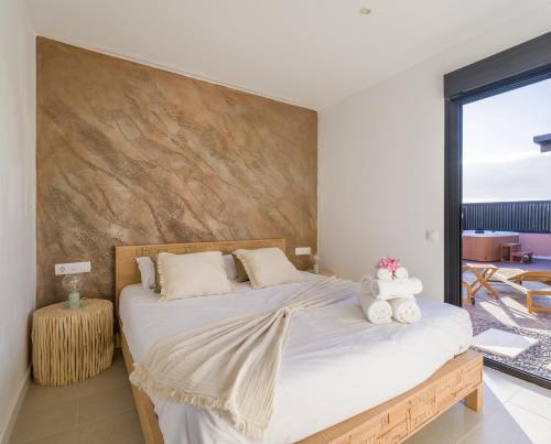 a bedroom with a large bed with a wooden headboard at Giraud I - Luxurious secluded villa next to the sea in Lajares