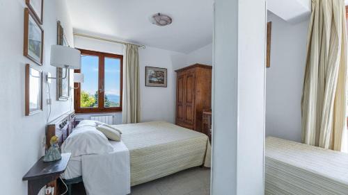 Un dormitorio con dos camas y una ventana. en Dalia, en Sassetta