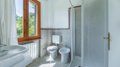 Un baño con inodoro, lavabo y ducha. en Dalia, en Sassetta