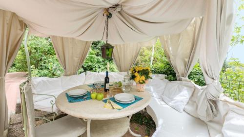a table and chairs under a canopy with a table at Erica in Sassetta