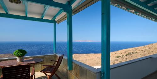 a table and chairs on a balcony with a view of the ocean at Lumina Kardiani in Kardiani
