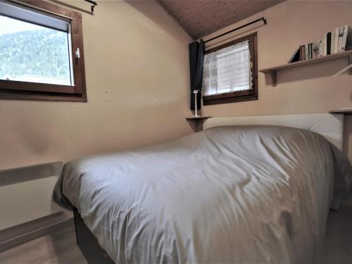 une petite chambre avec un lit et deux fenêtres dans l'établissement Charmant 2 pièces rénové avec balcon, wifi et parking, proche centre et commerces - FR-1-517-66, à Chamonix-Mont-Blanc