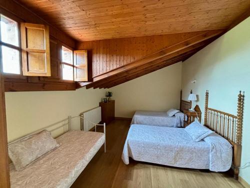 a attic room with two beds and a couch at La Casa Grande de Cabrales II in Canales