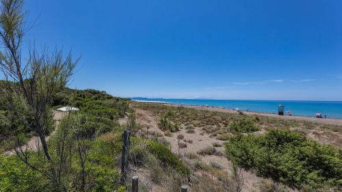 a beach with people on the sand and the ocean at Fresia in Sassetta