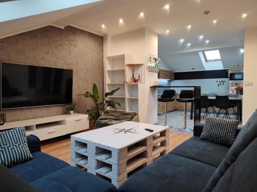 un soggiorno con un divano e una TV di Apartament Manhattan 2- KLIMATYZACJA a Słupsk