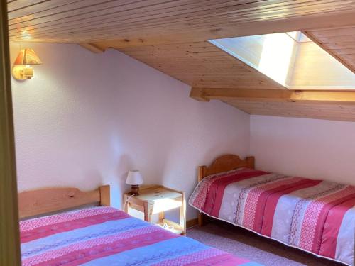 a attic room with two beds and a skylight at Duplex cosy à Termignon-Val Cenis, 7 pers, au pied des pistes, balcon, garage, Wi-Fi gratuit - FR-1-508-295 in Termignon