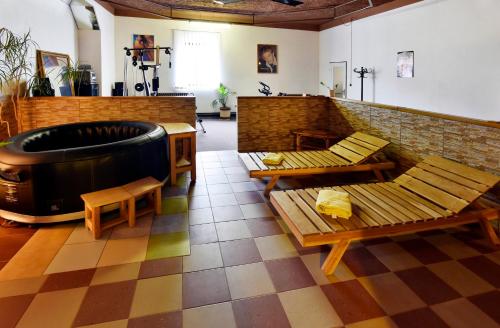 a large room with a tub and benches and tables at Hotel Kovarna in Děčín