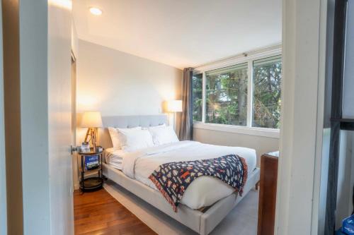 a small bedroom with a bed and a window at The Après Suite in Whistler