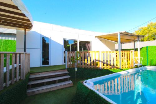 a backyard with a swimming pool and a house at Lodges de cedros in Setúbal