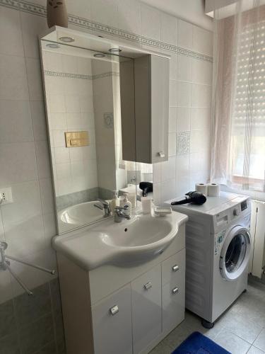 a bathroom with a sink and a washing machine at Golden Hour House in Termoli