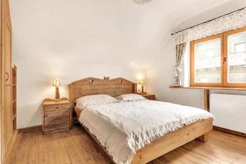 a bedroom with a wooden bed and a window at Chalet Vitranc in Kranjska Gora