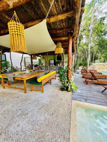 a pavilion with wooden tables and benches next to a pool at Lush Tulum Jungle Penthouse with Ensuite Rooftop Pool & HighSpeed Wifi in Balcheil