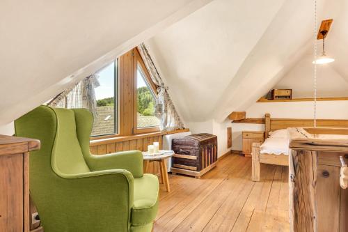 a room with a green chair in a attic at Chalet Vitranc in Kranjska Gora