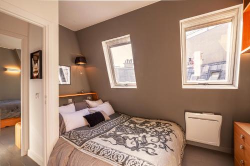 une chambre avec un lit et deux fenêtres dans l'établissement 1min Walk From Champs Elysées - Avenue Montaigne - AC - Self-Checkin - Working Desk, à Paris