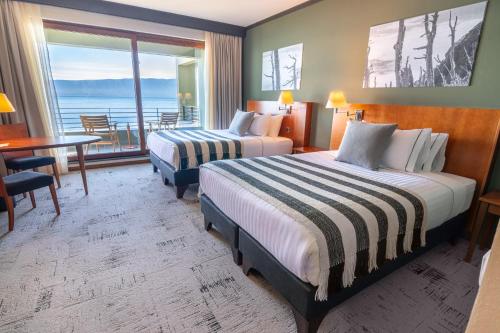 a hotel room with two beds and a table at Park Lake Luxury Hotel in Pucón
