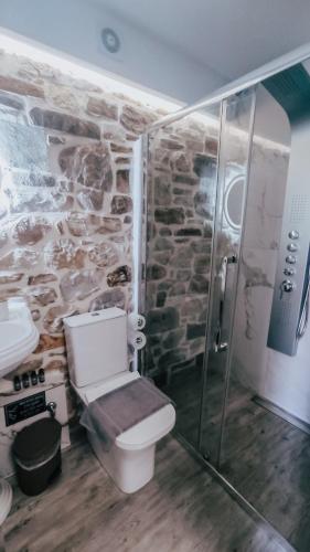 a stone bathroom with a toilet and a shower at Evaggelia's Stone Suites in Skala Marion