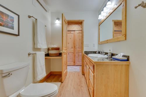 Un baño con inodoro, lavabo y espejo. en Near Skiing Studio with Pool Access in Granby!, en Granby