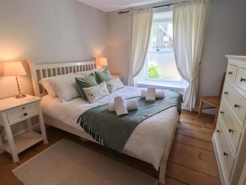 ein Schlafzimmer mit einem Bett mit zwei Handtüchern darauf in der Unterkunft Brook Cottage in Windermere