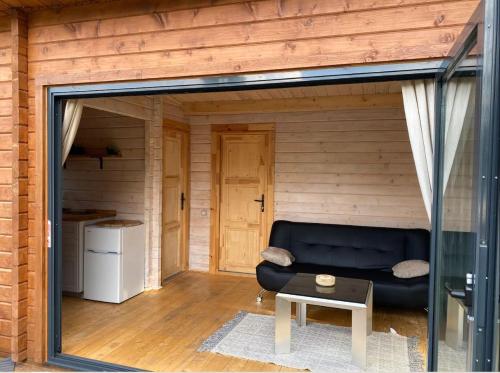 a living room with a black couch and a table at Langdale Lodge in Inverness