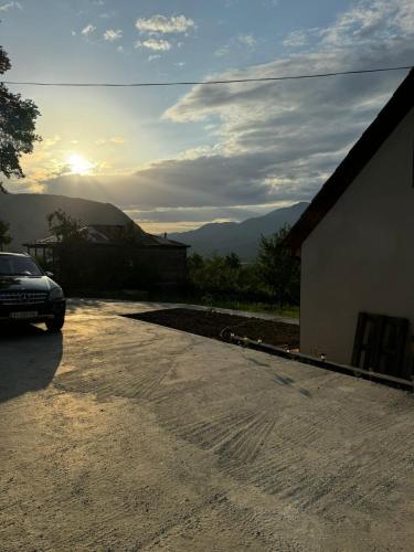 a car parked in a parking lot with the sunset in the background at Cottage space in Ambrolauri