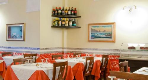 a dining room with tables and chairs and bottles of wine at Hotel Sicilia in Milan