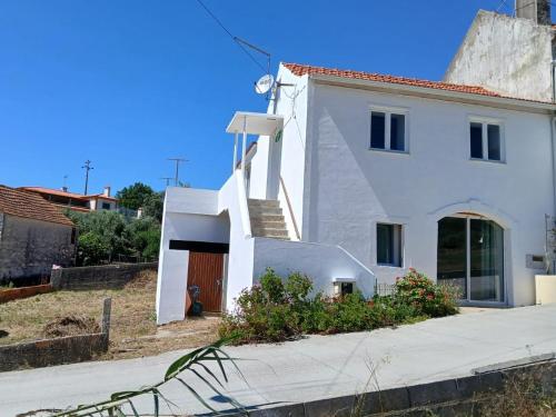 a white house with a staircase leading up to it at Maison proche Fatima batalha in Reguengo do Fetal