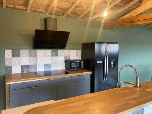 une cuisine avec un réfrigérateur en acier inoxydable et un comptoir dans l'établissement Loft spacieux, à Saint-Gervais