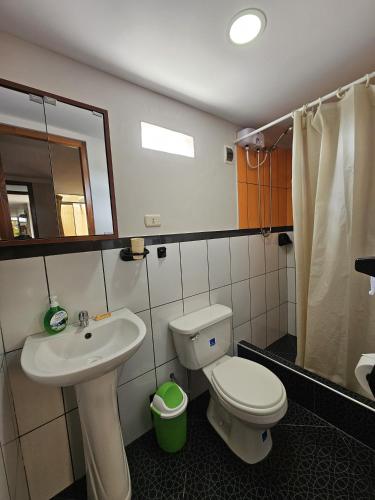 a bathroom with a sink and a toilet and a mirror at Anita Hostal in Chachapoyas