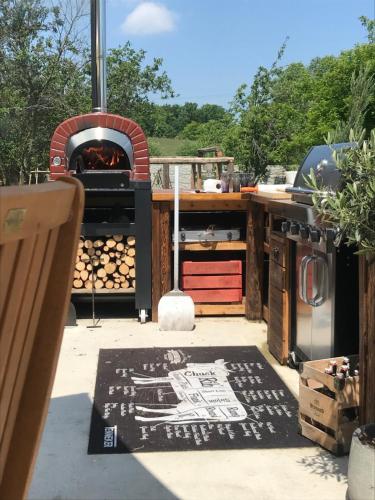 a patio with a pizza oven and a grill at OrchardHouse Farmhouse, wellness in Chrast
