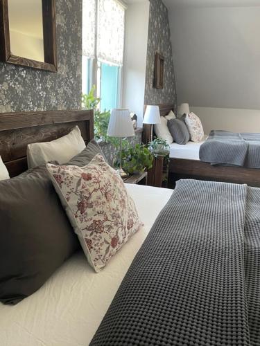 a bedroom with two beds and a bed with pillows at OrchardHouse Farmhouse, wellness in Chrast