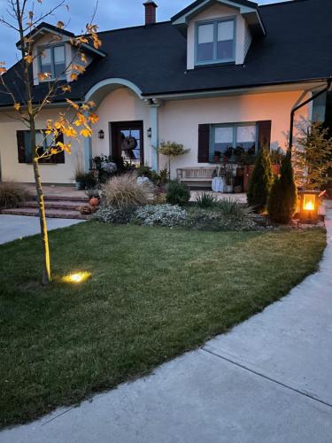 a house with a lawn with a tree in the yard at OrchardHouse Farmhouse, wellness in Chrast