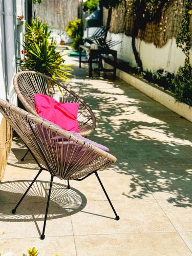 a chair with a pink bag sitting on a patio at Beach house with private swimming pool * 5 min walk to the beach in El Vendrell