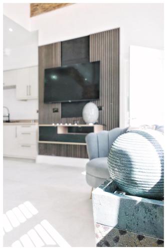a living room with a chair and a television at The Grandeur Mill in Bradford