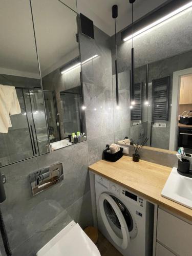 lavadero con lavadora y fregadero en Apartamenty na wydmach RB, en Międzywodzie