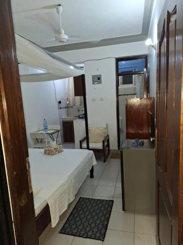 a small room with a bed and a kitchen at ANNA APARTMENTS MTWAPA in Mtwapa