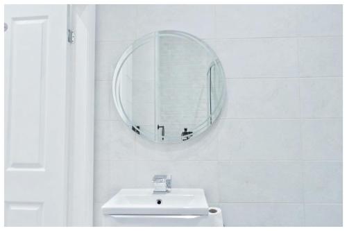 a white bathroom with a sink and a mirror at The Grandeur Mill in Bradford